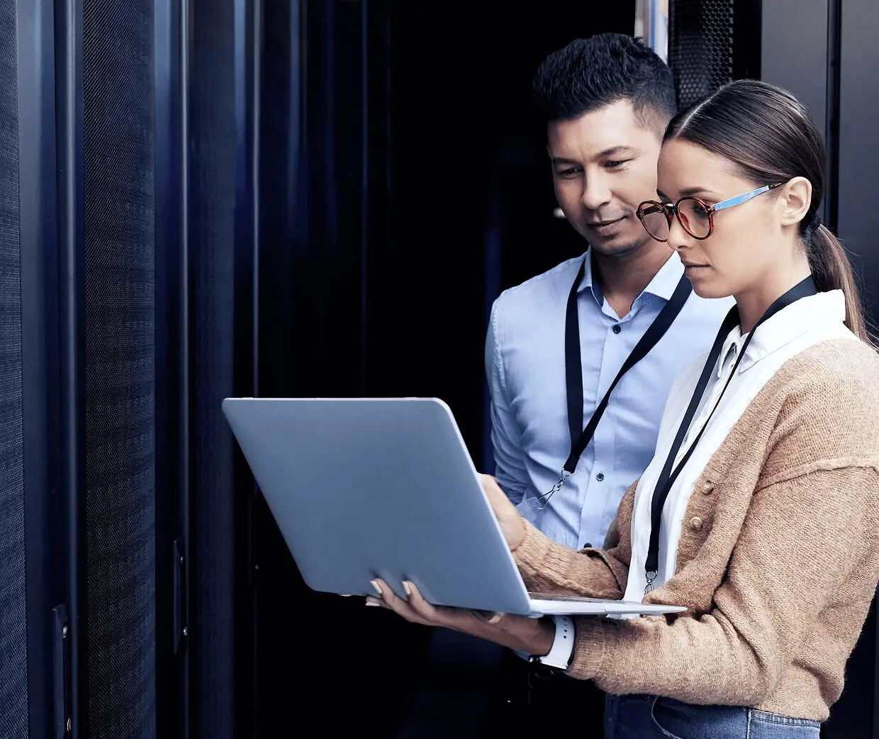 Two people working on a laptop server.
