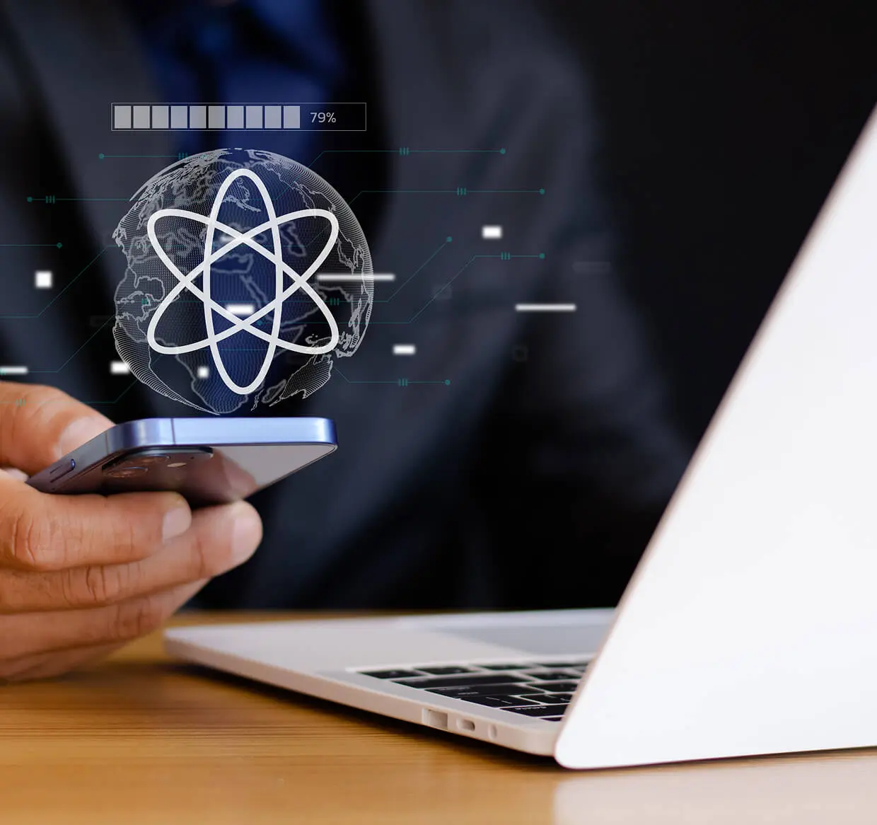 Man holding phone near laptop, digital globe.